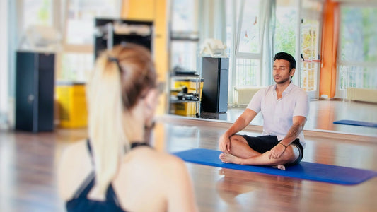 Pelvic floor exercises for male fertility, man sitting cross-legged on a yoga mat to support reproductive health naturally.