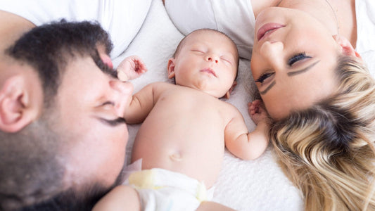 Family lying in bed with baby-symbolizing fertility, healthy beginnings, and the importance of fertilitywear for men.