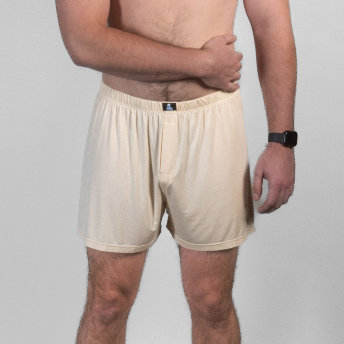 Male model in beige Mr. Fertyl bamboo Lyocell boxer shorts, front pose with arm across chest.