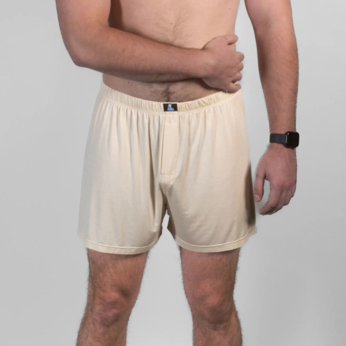 Male model in beige Mr. Fertyl bamboo Lyocell boxer shorts, front pose with arm across chest.