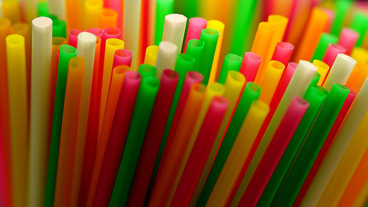 Polyester fertility risks symbolized by colorful plastic straws, representing synthetic fabrics and reproductive health.