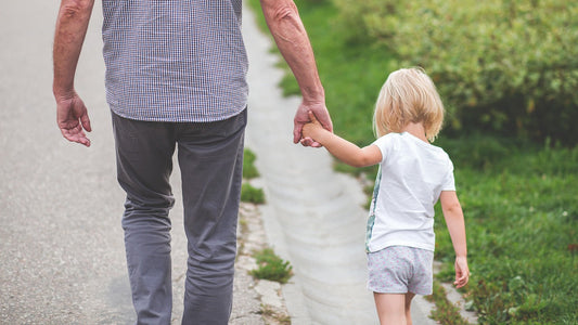 Father and child walking outdoors, representing male fertility, fatherhood, and healthy family lifestyle.